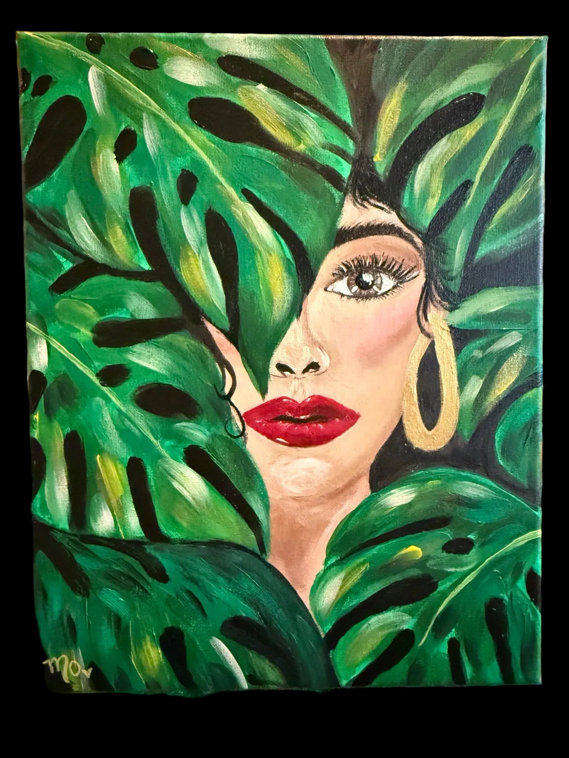 Expressive portrait of a woman surrounded by green tropical leaves